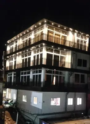 a building with lights on top of it at night at Alpha Inn in Vālpārai