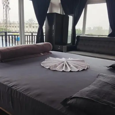 a large bed with a white umbrella on it at Alpha Inn in Vālpārai