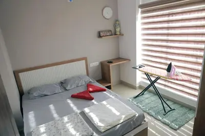 a bedroom with a bed with red pillows on it at Vaiga Heavens , 1 BHK Apartment in Guruvāyūr