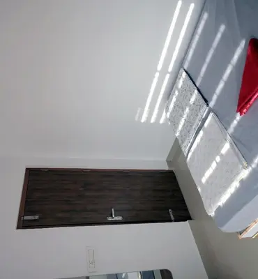 a room with a white ceiling with a window and aartments at Vaiga Heavens , 1 BHK Apartment in Guruvāyūr