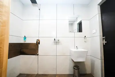 a white bathroom with a sink and a shower at IGNIVA Airport Hotel in Calicut