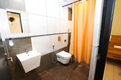 a bathroom with a sink and a toilet at IGNIVA Airport Hotel in Calicut