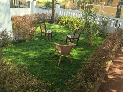 two chairs and a table in a yard at Formula 1 Premium Villa in Mysore
