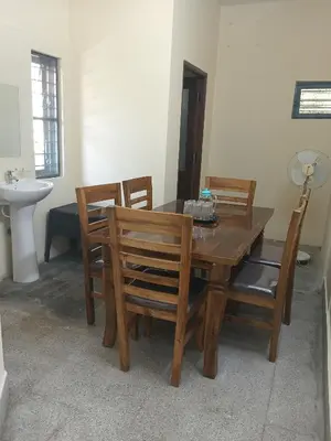 a dining room with a table and chairs and a sink at Formula 1 Premium Villa in Mysore