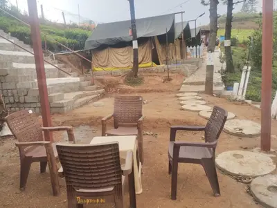 a group of chairs and tables in the dirt at Janardan Campsite Ooty in Ooty