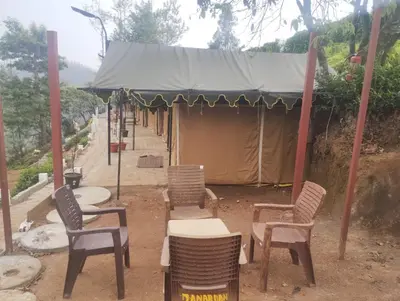 a group of chairs and tables in front of a tent at Janardan Campsite Ooty in Ooty