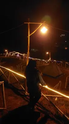 a person standing under a street light at night at Oak and Sky Adventures, Kanthalloor in Kanthalloor