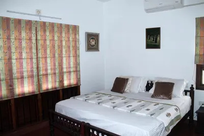 a bedroom with a bed in a room at Heritage Home Near Cochin Airport in 5-Acre Farm in Angamali