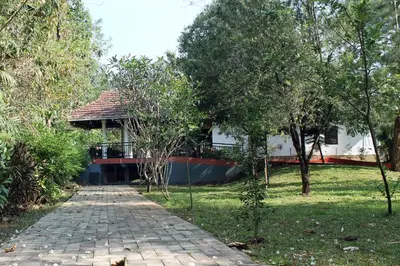 a house with a walkway in front of a yard at Heritage Home Near Cochin Airport in 5-Acre Farm in Angamali