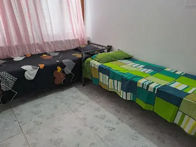 two beds sitting next to each other in a room at Kunjoose Ladies Hostel in Trichūr