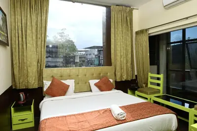 a bedroom with a bed and a large window at Valparai home villas in Vālpārai