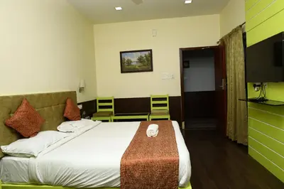 a hotel room with a bed and a television at Valparai home villas in Vālpārai