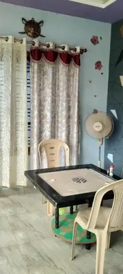 a ping pong table and chairs in a room at Greeneysthomestay in Kushālnagar