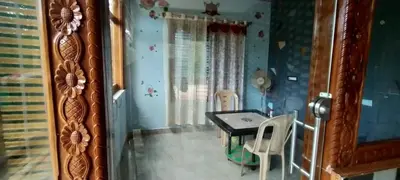 a dining room with a table and chairs in a room at Greeneysthomestay in Kushālnagar