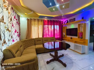 a living room with a couch and a table at Greeneysthomestay in Kushālnagar