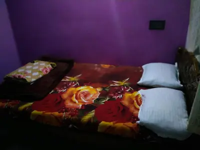 a bed with flowers on it in a purple room at Greeneysthomestay in Kushālnagar