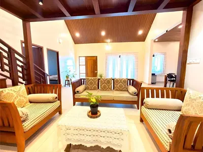 a living room with two couches and a table at Evara Stays Coorg in Kushālnagar