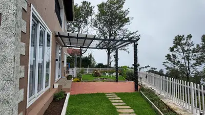 a garden with a pergola on the side of a house at Amariyah House -Luxury Villa in Coonoor in Coonoor