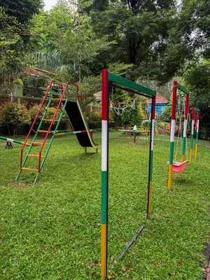 a row of playground equipment in a park at Maple grove villa resort in Panamaram