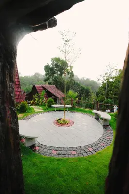 a view of a park with benches and a tree at Wood Panda Luxury Resort Wayanad in Meppādi