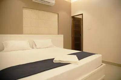 a bedroom with a large white bed with a window at Gentur Enclave in Mananthavady