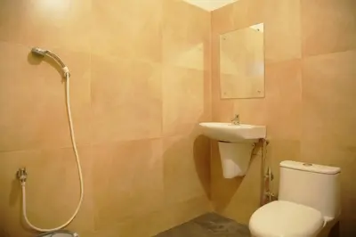 a bathroom with a toilet and a sink and a shower at Gentur Enclave in Mananthavady
