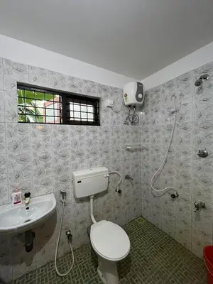 a bathroom with a toilet and a sink at Mathangi - A Countryside Homestay for Family and Solo Travelers in Kozhikode