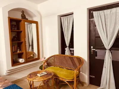 a room with a chair and a table and a mirror at Mathangi - A Countryside Homestay for Family and Solo Travelers in Kozhikode