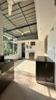 a large kitchen with black counter tops in a room at Snehanilayam-1 in Trichūr