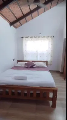 a bedroom with a large wooden bed with a window at Blue chill villa in Madikeri