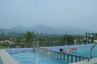 a man laying in a swimming pool at Blue Vista Residency in Kalpetta