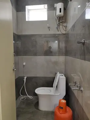 a small bathroom with a toilet and a window at Eshwaraa Cottage in Palani