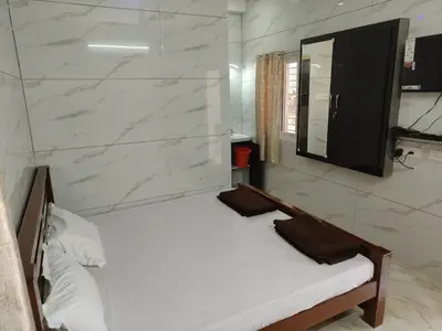 a bedroom with a white bed and a mirror at Eshwaraa Cottage in Palani