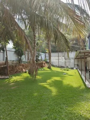 a yard with palm trees and green grass at Eshwaraa Cottage in Palani