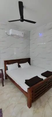a bedroom with a bed and a ceiling fan at Eshwaraa Cottage in Palani