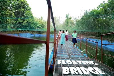 a group of people standing on a bridge over a river at Haritha Bio Park Homestay in Malayāttūr