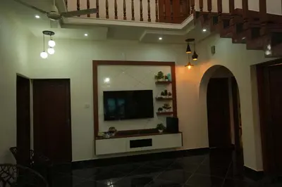 a living room with a flat screen tv on a wall at Haritha Bio Park Homestay in Malayāttūr