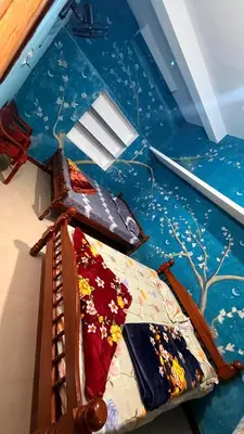 a room with a bed and a painting on the floor at Adi Home Stay in Vālpārai