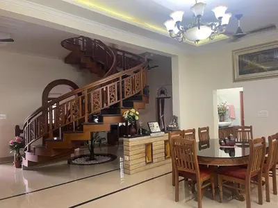 a dining room with a staircase and a table and chairs at Authentic Keralite holiday home for up to 6 in Kāladi