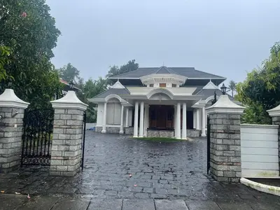 a large white house with a black gate at Authentic Keralite holiday home for up to 6 in Kāladi