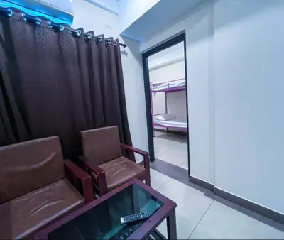 a room with a chair and a table and a mirror at krishna suites guruvayur in Guruvāyūr