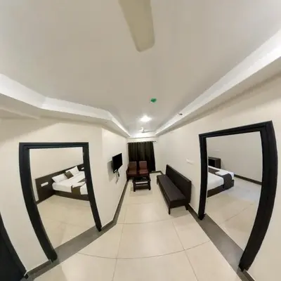 two mirrors in a room with two beds at krishna suites guruvayur in Guruvāyūr