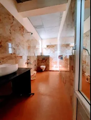 a bathroom with a sink and a toilet at Glass house in Pollāchi