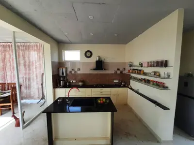 a kitchen with a sink and a counter top at Glass house in Pollāchi