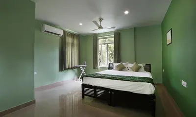 a bedroom with green walls and a bed at Family beach home-Cherai in Pallipuram