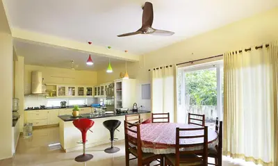 a kitchen with a table and chairs and a ceiling fan at Family beach home-Cherai in Pallipuram