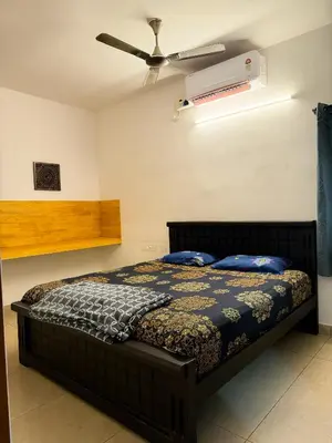 a bedroom with a bed and a ceiling fan at SRK luxe resort