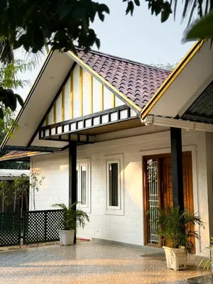 a white house with a black and yellow roof at SRK luxe resort