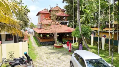a house with a car parked in front of it at Atharvam Resort in Cherai Beach