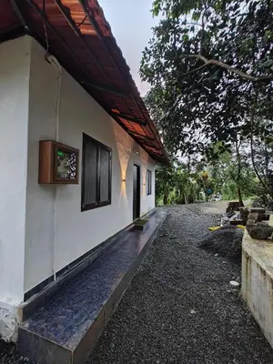 a side view of a white building with a porch at Hayden in Kakkadampoyil